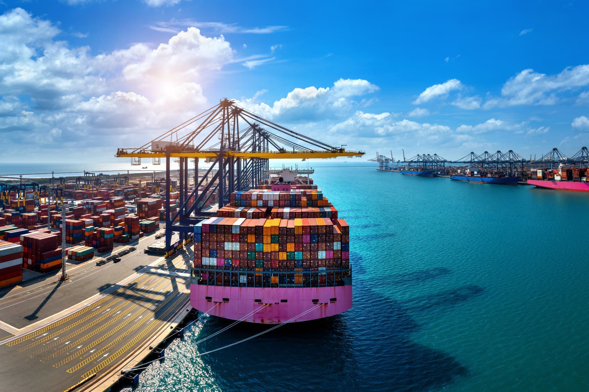 Sea freight container ship at a port terminal with gantry cranes